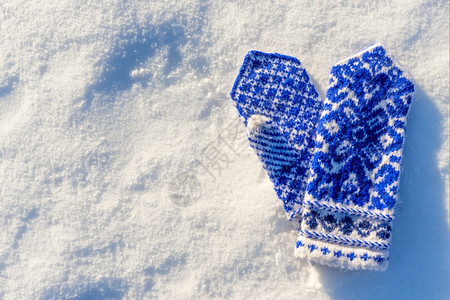 雪中充满美丽图案的温暖羊毛手套图片