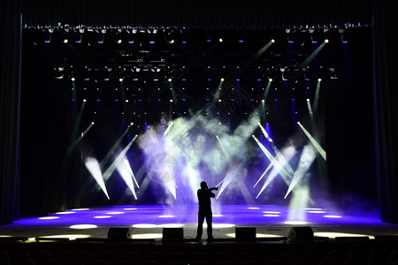 歌唱男伴在明亮的音乐会舞台上轮光图片