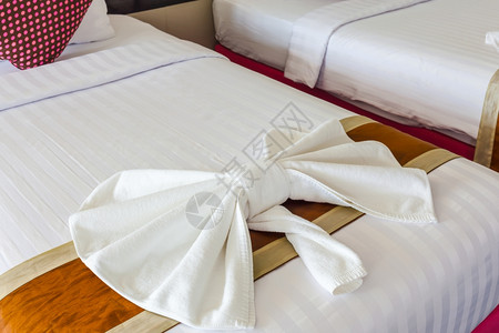 白毛巾在床上折叠成弓形图片