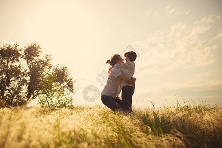 日落时情侣在田野间拥吻图片