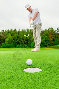 男子在绿地打高尔夫图片