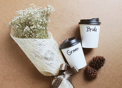 新郎和娘写在咖啡杯上盛花束用于婚礼概念图片