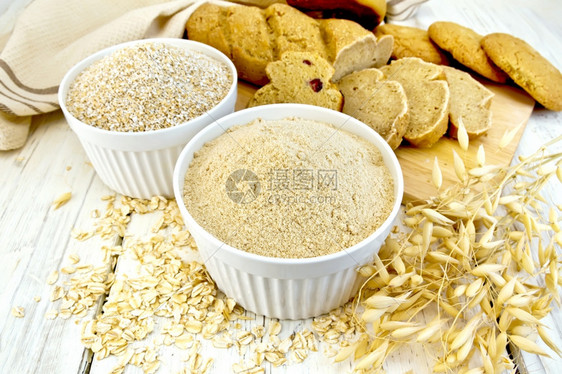 白碗燕麦和茎面包饼干木板背景的餐巾图片