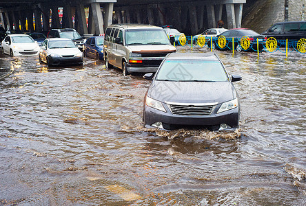 汽车在河水泛滥的车道上行驶图片
