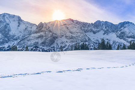 太阳照耀在被雪覆盖的山上图片