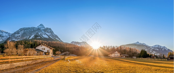 美丽的山地风景与一个叫ehrwald的小村庄位于奥斯特里亚阿尔卑山脚下在晴朗的蓝天和华丽太阳下图片