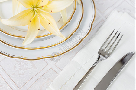 漂亮的装饰桌上面有白色板餐巾纸具和豪华桌布上的鲜花图片
