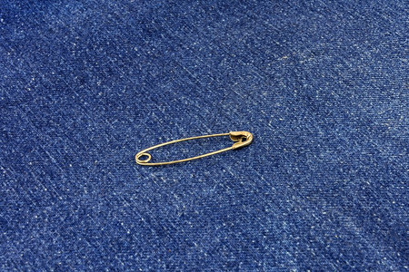 蓝色牛仔裤材料上的金属扣针图片
