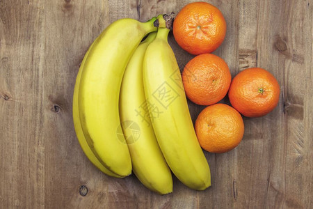 香蕉橘子在木制表面的香蕉和橘子上背景