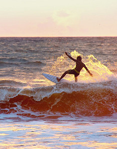 日落时在海洋冲浪图片