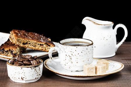 古老的陶瓷杯装有咖啡豆和巧克力蛋糕图片