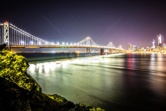 晚上在加州的奥克兰湾桥与圣弗朗西斯科的天际连线图片