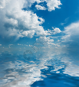 巨大的蓝色夏日天空全光白毛色积雪云反射在小波浪的水面上图片