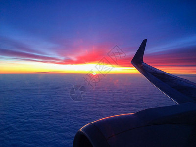 日落时飞机机翼在云彩中行驶图片