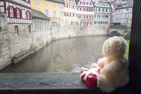 分享有礼穿着红礼的可爱泰迪熊坐在木梁和德国建筑的幕后上位于德国的斯瓦比舍大厅背景