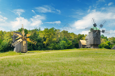 田野和天空中的老木形风车背景图片