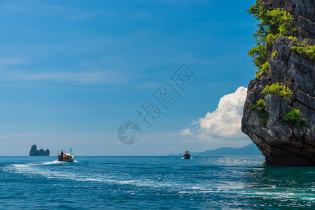 在美丽的岩石附近在安达曼海中装有发动机的快木船图片