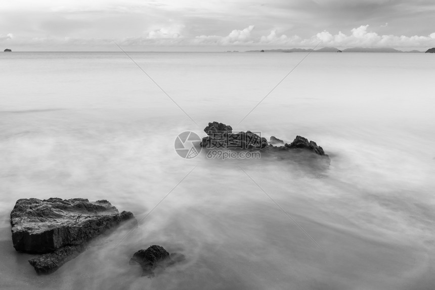 海浪冲洗滩上的黑白摄影石和图片