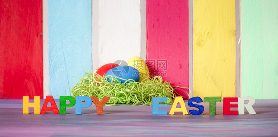 东面横幅上写着快乐的东方人写着多色字母和彩蛋放在紫色桌子上图片