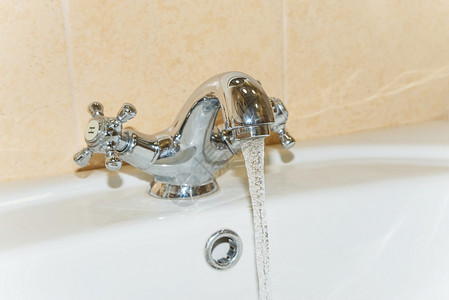 清洁饮用水从浴室的钢龙头流出图片