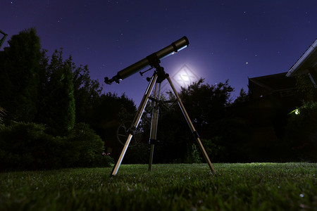 家夜天文学和恒星观测概念一架望远镜站在后院其背景为夜空背景