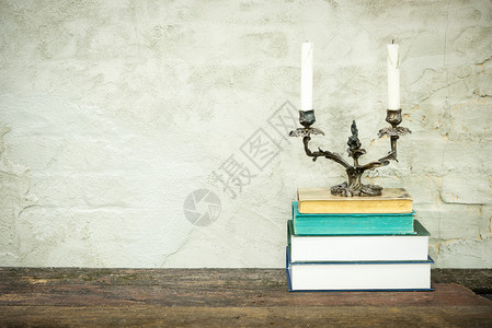 白酒酿造由古老的旧书木甲板桌上的日记和米色混凝土背景组成的丰富多彩份上面堆叠着经典烛台的书回到学校复制空间教育背景背景