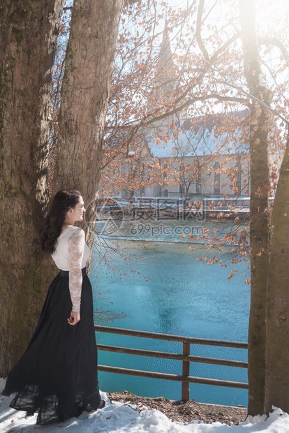 穿着黑裙子的发年轻女人仰着一棵树沉思在blautopf泉边位于blauern的德国河边图片
