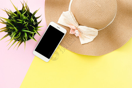夏季旅行的平板设计概念夏季帽子的顶部视图在粉色黄面条彩屏幕上模拟智能手机和小树复制空间夏季旅行时用面条彩色背景图片