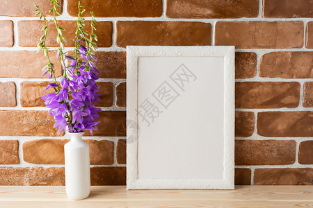 在砖墙附近的花瓶中用紫色露天日的白光板图片
