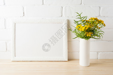 白色地貌框架以在油漆砖墙附近的花瓶中野生金黄色花朵为模型空框架模拟演示设计现代艺术的模板白色地貌框架模拟在油漆砖墙附近的黄色花朵图片