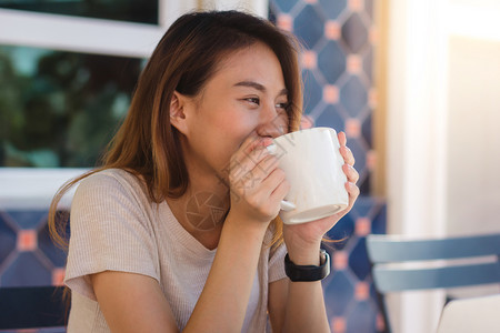 早上在咖啡馆喝时手拿着杯子的快乐年轻女商人肖像在咖啡馆或店表达情感放松图片