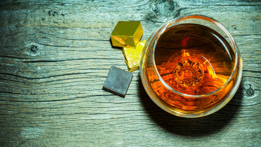 威士忌杯和巧克力在木制背景的顶层视图上威士忌杯和巧克力顶层视图上背景图片