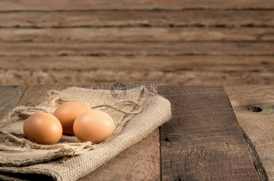 在木制板凳上新产有机鸡蛋在土制木板凳上新产有机鸡蛋在土制板凳上新产棕色有机鸡蛋在土制木板上布麻袋安排褐色有机鸡蛋在木制板凳上新产图片
