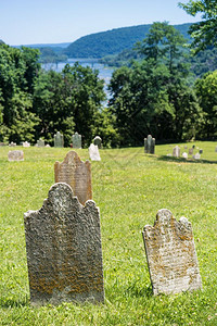 在西弗吉尼亚州竖琴渡轮上方的墓碑旧苔榈和地衣覆盖了墓碑上方的旧苔榈覆盖了竖琴渡轮上的墓碑背景图片