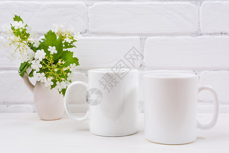 两杯白咖啡装饰品配有鲜花的烧肉枝空杯装饰品配有鲜花用于设计促销图片