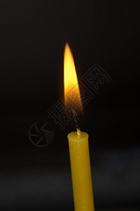 燃烧的蜡烛黄蜡烛在抽象的黑暗背景上背景