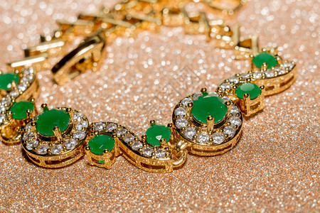 翡翠优雅的女首饰金手镯配有珍贵的绿宝石背景