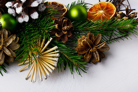 圣诞树枝有草星和松果圣诞节背景有干橙片和锈制装饰品图片