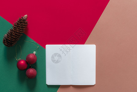 圣誕概念以最低的风格白色空笔记本红色的圣诞球和松果红色的绿橙图片