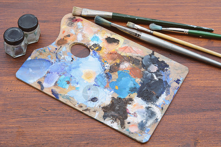 艺术家配有多彩油色画笔和木制背景的调色板艺术概念图片