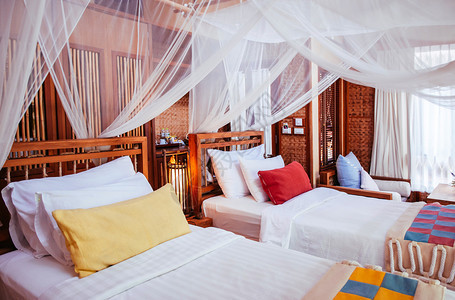 2013年6月日泰王国kanchburihlnd亚式卧室内四张挂着窗帘和彩色织布枕头的海报床图片