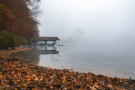 用木质屋顶和船锚在阿尔普西湖上周围是迷雾和秋天的森林靠近小鸡巴伐利亚德意志图片