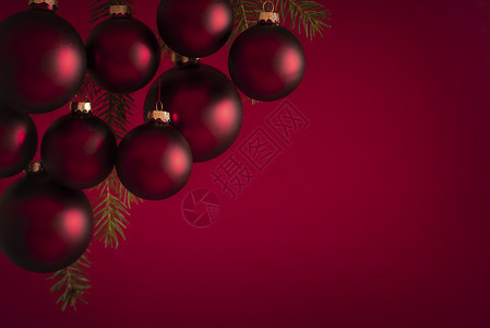 圣诞节横幅上挂着毛发红球在树枝上红色模糊的背景适合贺卡或圣诞节背景图片
