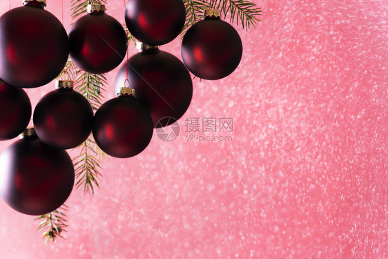 优雅的深红色圣诞球在下雪时挂着从喷雾中在明亮的光线下完美地用于圣诞节贺卡或旗帜图片