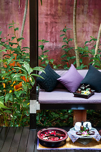 2013年月日NevsamuiThlnd在热带Thai度假胜地花园设置脚温疗配有多彩的旧水泥墙绿色植物和配花的SPa碗图片