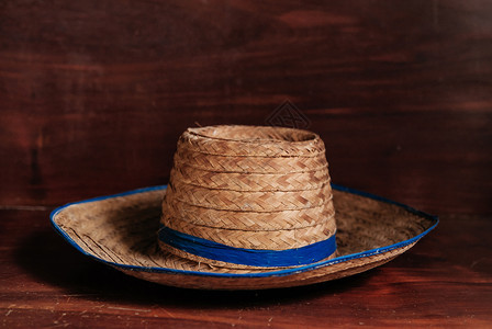 古老的亚洲风格草帽在木材背景上带蓝丝的生锈农帽图片