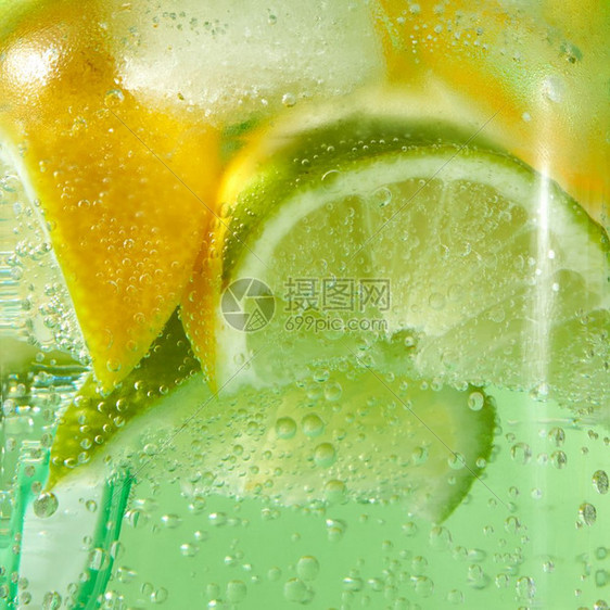 以冰石灰片柠檬和彩色塑料吸管在玻璃中闪亮的新鲜柠檬并配有冰柠檬和彩色塑料吸管并配有大气泡冷饮酒精或非夏季饮料的概念天然水果背景配图片