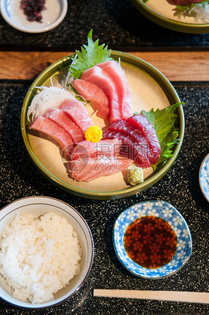 新鲜鲑鱼金托罗马朱面鱼在陶瓷板上配有黄沙司和日本当地食品的菜图片