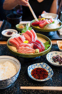 新鲜鲑鱼金托罗马朱托鱼尾生片和餐桌上陶瓷板的黄玉子图片