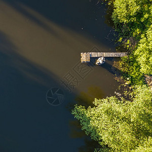 在阳光的夏日无人机拍摄的照片在阳光明媚的一天木桥小湖和森林的顶部视图图片